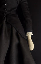 Load image into Gallery viewer, Madeleine's body from mid torso to mid thigh. Her black jacket and skirt are featured, as well as her left arm and the cream colored antique linen cuff of her sleeve.