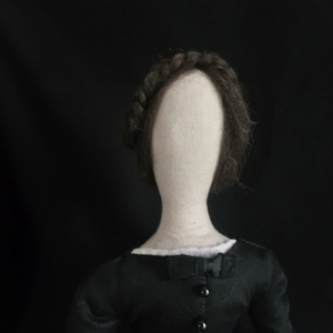 Another shot of Madeleine's face and hair, which features a center part and a braid over the crown of her head.