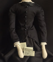 Load image into Gallery viewer, Madeleine is seated against a dark backdrop. The focus is on her torso and lap, in which sit three tiny love letters.
